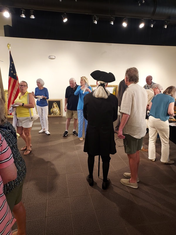 "Visitors viewing exhibits and conversing in an indoor gallery or museum setting."