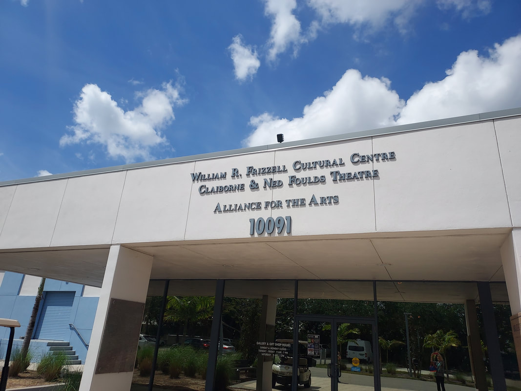 William R. Frizzell Cultural Centre and Claiborne & Ned Foulds Theatre, showcasing arts and cultural events, located at 10091. Blue sky in backdrop.