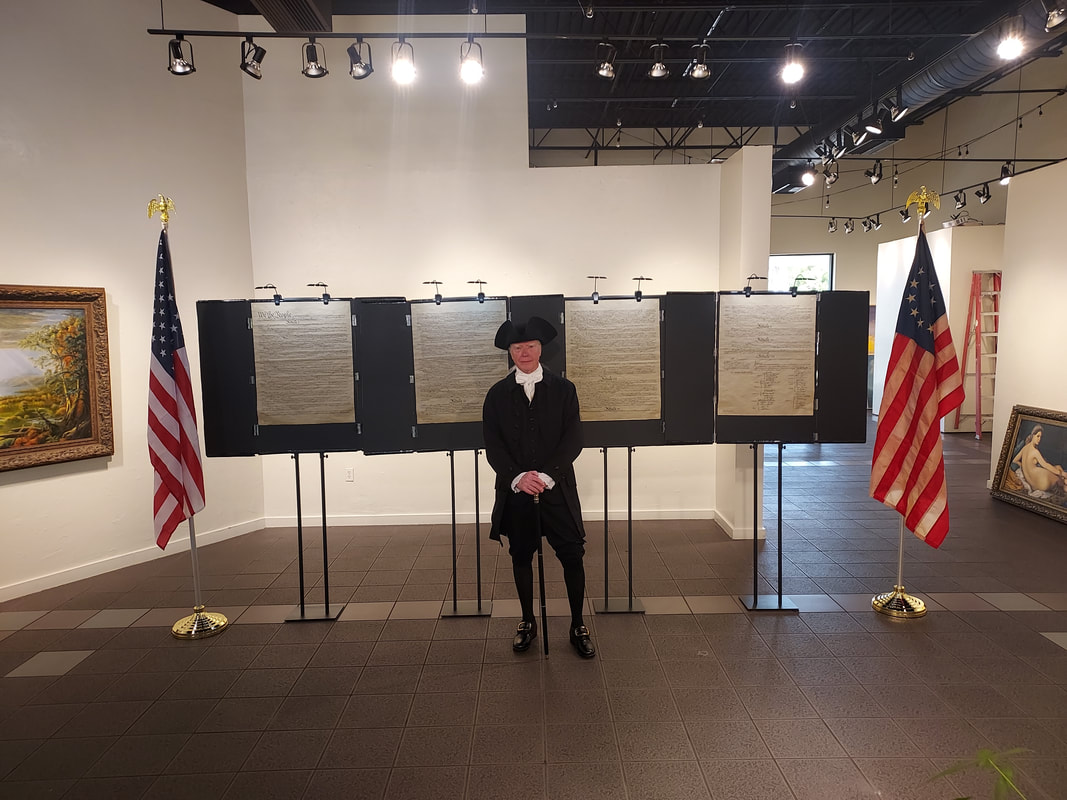"Presentation area with display boards and flags arranged inside an exhibition room."